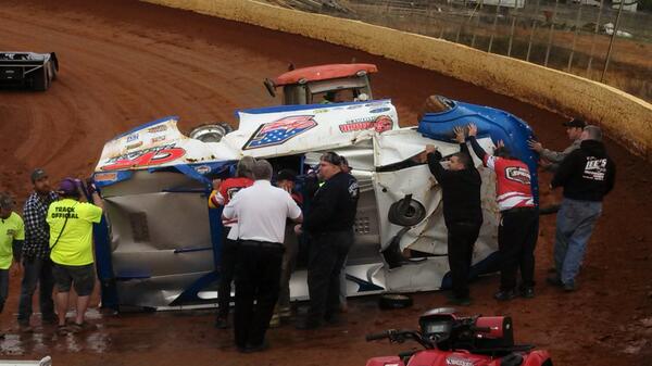 Track workers at Smoky Mountain Speedway work to roll Mark Vineyard's car onto its wheels.
