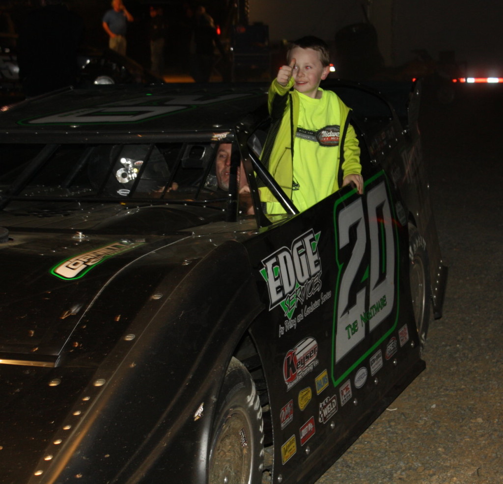 Nathan Owens gives the thumbs up as he rides on his dad's car